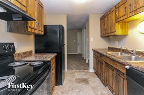 Indianapolis house for rent - A kitchen with a black stove top oven and black refrigerator.