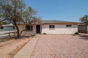 Phoenix house for rent - A house with a driveway and a tree in front.