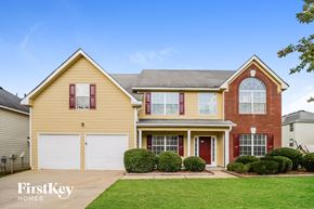 Atlanta house for rent - a house with two garage doors and a lawn