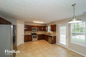 Atlanta house for rent - a kitchen with wood cabinets and stainless steel appliances and a large window