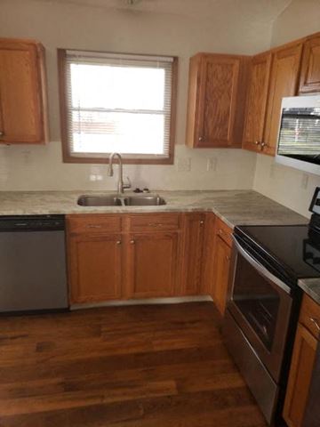 Galloway house for rent - a kitchen with wooden cabinets and a sink and a window