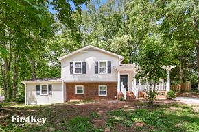 Charlotte house for rent - a white house with trees in front of it