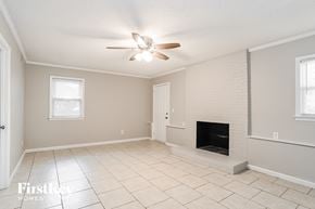 Charlotte house for rent - a living room with a fireplace and a ceiling fan
