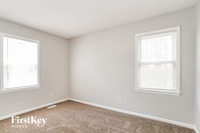 Charlotte house for rent - a bedroom with two windows and a carpeted floor