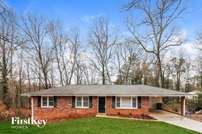 Acworth house for rent - A brick house with a grey roof and a green lawn in front.