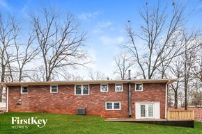 Acworth house for rent - A brick house with a white door and windows is surrounded by trees.