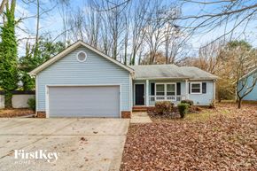 Charlotte house for rent - A blue house with a white garage door is for sale.