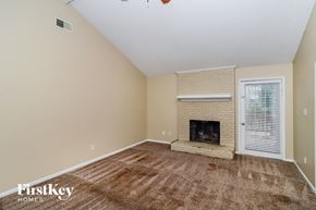 Charlotte house for rent - A room with a fireplace and a window with blinds.