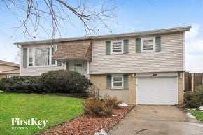 Oak Forest house for rent - a tan and green house with a white garage door