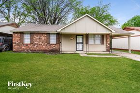 Memphis house for rent - a small brick house with a lawn and a driveway