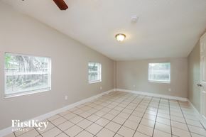 Hollywood house for rent - A room with white tiled floors and two windows.