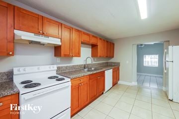 Hollywood house for rent - A kitchen with white appliances and orange cabinets.