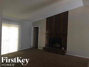 Memphis house for rent - an empty living room with a fireplace and a window