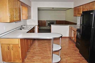 Indianapolis house for rent - a kitchen with wooden cabinets and a white counter top