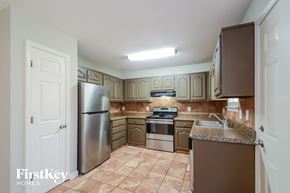 Pinson house for rent - a kitchen with white cabinets and stainless steel appliances