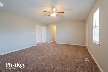 Pinson house for rent - a spacious living room with carpet and a ceiling fan