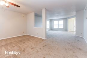 Indianapolis house for rent - an empty living room with a ceiling fan and a window