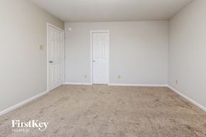 Indianapolis house for rent - a bedroom with a carpeted floor and two doors