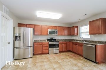 Clemmons house for rent - a kitchen with wooden cabinets and stainless steel appliances