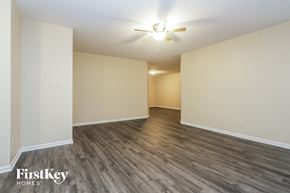 Indianapolis house for rent - A spacious room with wooden flooring and a ceiling fan.