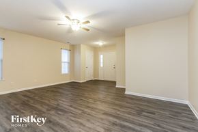 Indianapolis house for rent - A spacious room with a ceiling fan and wooden flooring.