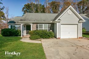 Greensboro house for rent - a small blue house with a driveway and a white garage door