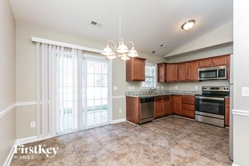 Greensboro house for rent - a kitchen with wood cabinets and stainless steel appliances and a large window