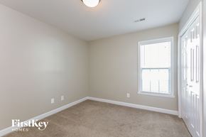 Greensboro house for rent - a bedroom with a carpeted floor and a window