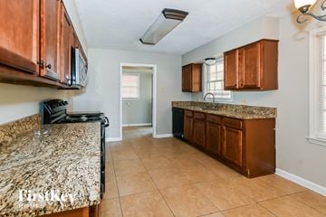 Memphis house for rent - a kitchen with wooden cabinets and granite counter tops