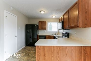 Galloway house for rent - a kitchen with wooden cabinets and a black refrigerator