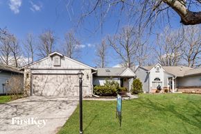 Indianapolis house for rent - a white house with a driveway and a white garage door