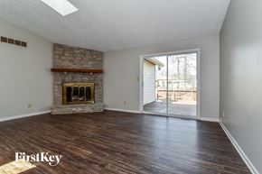 Indianapolis house for rent - an empty living room with a fireplace and a sliding glass door