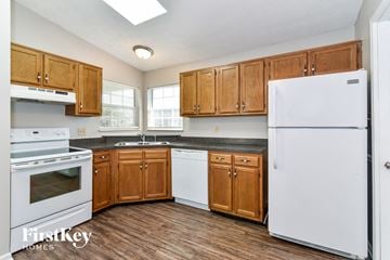 Indianapolis house for rent - a kitchen with white appliances and wooden cabinets