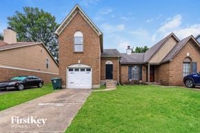 Memphis house for rent - a brick home with a white garage door and a lawn