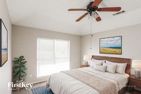 Arlington house for rent - A bedroom with a large bed, a ceiling fan, and a painting on the wall.