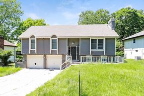 Parkville house for rent - a gray house with a driveway and a white garage door
