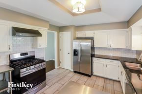 Parkville house for rent - a kitchen with stainless steel appliances and white cabinets