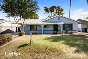 Tempe house for rent - a white house with a yard and a yard sign