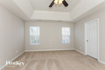 Matthews house for rent - a spacious living room with carpet and a ceiling fan