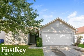 Indianapolis house for rent - a white house with a white garage door and a green lawn