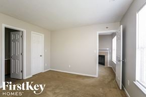 Indianapolis house for rent - a living room with a carpeted floor and a door to a fireplace