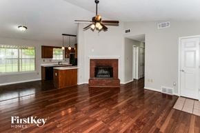 Millington house for rent - A spacious living room with wood flooring and a fireplace.