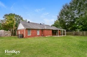 Millington house for rent - A house with a red brick exterior and a white roof is surrounded by a grassy yard.