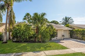 Lake Worth house for rent - a house with palm trees and a driveway