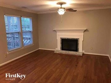 Charlotte house for rent - a living room with a fireplace and a ceiling fan