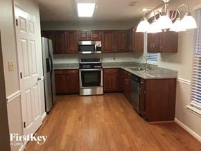 Charlotte house for rent - an empty kitchen with wooden floors and stainless steel appliances