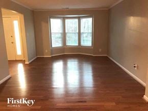 Charlotte house for rent - an empty living room with wood floors and a window