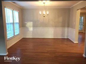 Charlotte house for rent - an empty dining room with wood floors and a chandelier