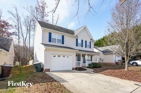 Greensboro house for rent - A white house with a blue stripe on the windows and a garage door.