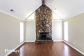 Memphis house for rent - a living room with a stone fireplace and wooden floors